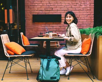 Young woman sitting at a café working and smiling 