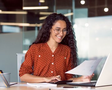 hispanic looking business woman working with laptop and smiling